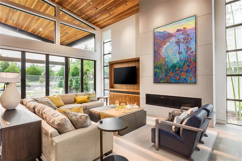 Thick brushstrokes of bold, impressionistic color fill this large canvas with the colors of California—aqua blue, royal lavender, burgundy, and taupe. California poppies and yellow mustard plants bloom in the foreground, creating a sense of depth and atmosphere in the painting. 